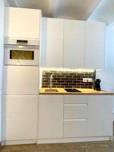 een keuken met witte kasten en een fornuis met oven bij Barcelona COZY Apartment in Hospitalet de Llobregat