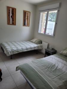 1 Schlafzimmer mit 2 Betten und einem Fenster in der Unterkunft UN AIR DE VACANCES in Layrac