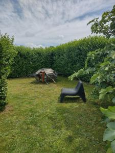 a picnic table and a bench in the grass at Land Scape guesthouse in Eeklo