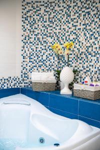 La salle de bains est pourvue d'une baignoire et d'un mur carrelé bleu. dans l'établissement YourHome - Casa Barba Positano, à Positano 23 autres photos