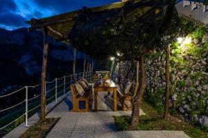 une table et des chaises assises sous un kiosque dans l'établissement YourHome - Casa Barba Positano, à Positano