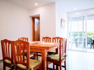 una sala da pranzo con tavolo e sedie in legno di ADOSADO NUEVA OROPESA a Oropesa del Mar