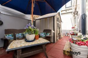 een patio met een tafel en stoelen en een parasol bij Seaview House in Blackpool