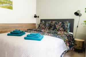a bed with two blue towels on top of it at Blommehûs in Workum