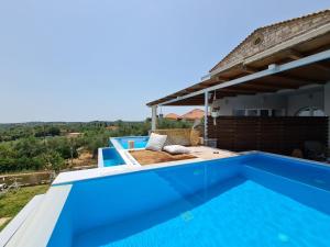 a villa with a swimming pool and a house at Georgianna's suite with private pool , 'greysuite' in Kómpoi