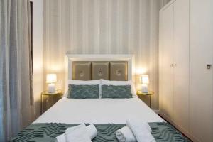una camera da letto con un grande letto bianco con due lampade di ECO CENTER GRANATENSIS CATEDRAL 2 habitaciones free párking a Granada