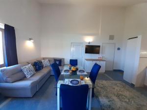 ein Wohnzimmer mit einem Sofa, einem Tisch und blauen Stühlen in der Unterkunft Romantic Apartment by the Beach in Malinska