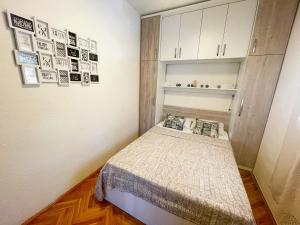 ein kleines Schlafzimmer mit einem Bett und weißen Schränken in der Unterkunft Apartman Lu&Ni in Dramalj