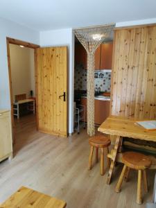 a room with a wooden table and benches and a kitchen at Appartamento Elda La Thuile in La Thuile