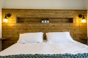 ein Schlafzimmer mit einem Kopfteil aus Holz und einem Bett mit zwei Kissen in der Unterkunft Edge of Padstow, 2 bedroom luxury lodge in Padstow + 40 Fotos