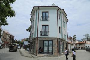 Gokceada Marmaros Butik Otel في غوكجيادا: شخصين واقفين أمام مبنى
