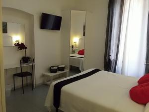 una camera d'albergo con letto e specchio di Hotel Birillo a La Spezia