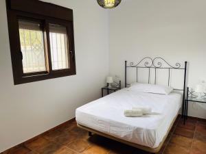 una camera da letto con un letto bianco con testiera in ferro battuto di El Refugio 2 a Los Caños de Meca