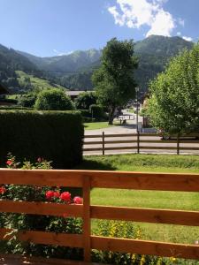 a wooden fence in front of a park with flowers at Landhaus Elto in Kaprun