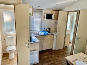 a small kitchen with a sink and a toilet at Camping River in Le Martinet