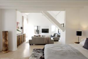 een witte kamer met een bed en een woonkamer bij Strandloper Ocean Boutique Hotel in Paternoster