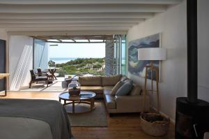 a living room with a couch and a table at Strandloper Ocean Boutique Hotel in Paternoster