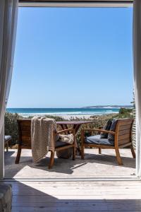 a patio with chairs and a view of the beach at Strandloper Ocean Boutique Hotel in Paternoster