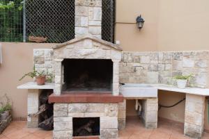 una chimenea de piedra en un patio con fregadero en Heraklion Comfy House with Mountain View, en Heraclión
