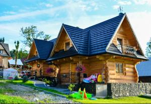 a log cabin with a blue roof at Luksusowe Domki Elizy Luxury Chalets Poronin in Suche
