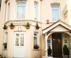 un edificio con una porta e piante sopra di The Norman Guest House a Dover