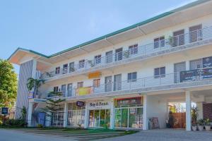 a large white building with balconies on top of it at RedDoorz At Fat J Apartelle Mactan in Cebu City