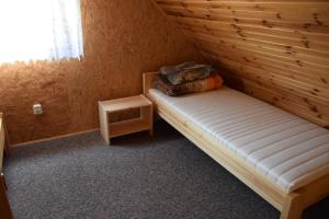 um quarto com uma cama num quarto de madeira em Ośrodek Wypoczynkowy Babiński em Władysławowo