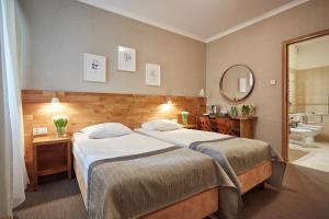 ein Hotelzimmer mit 2 Betten und einem Bad in der Unterkunft Hotel Batory in Krakau