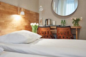 a bed with a white pillow and a mirror at Hotel Batory in Kraków