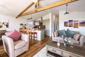 a living room with two couches and a table at Edge of Padstow, 2 bedroom luxury lodge in Padstow
