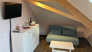 a room with a couch and a tv in a attic at BürgerhausLöwen in Philippsburg