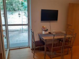 ein Esszimmer mit einem Tisch und einem TV an der Wand in der Unterkunft Apartmán LauMar 2 in Bzenec