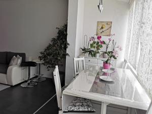 a white table in a living room with potted plants at Apartment Orchidee in Pula