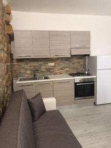 sala de estar con sofá y cocina en Appartamenti via cala sisine, en Santa Maria Navarrese