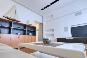 a living room with a table and a tv at Apartment light in Pula in Pula