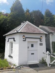 a small white garage with a white door at The Welsh Toll House in Carmarthen