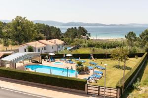 un complejo con piscina y playa en Hotel Canelas, en Portonovo