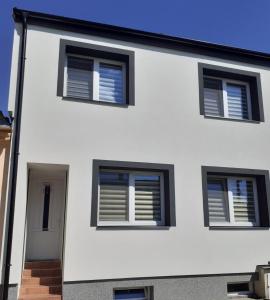 a white house with four windows on it at Apartmán LauMar 2 in Bzenec