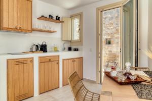 a kitchen with wooden cabinets and a table and chairs at Shizen Houses in Serifos Chora +39 photos