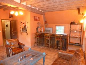 a living room with a bar with a table and chairs at Manoir De Savigny in Valognes