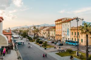 een straat met gebouwen en mensen die op straat lopen bij BeB BALENA in Viareggio