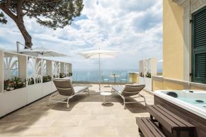 a balcony with a hot tub and chairs and a table at Sublimis Boutique Hotel Adults-Only in Camogli