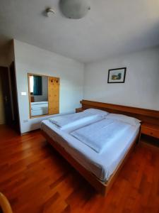 a large bed in a bedroom with a wooden floor at Pension Marianne in Maranza