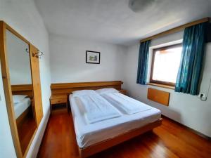a bedroom with a large bed and a window at Pension Marianne in Maranza