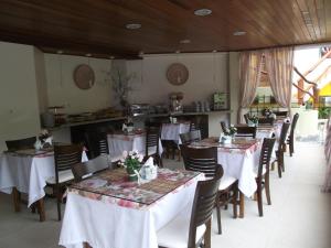 um restaurante com mesas e cadeiras com toalha de mesa branca em Pousada Safira do Morro em Morro de São Paulo