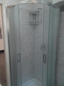 y baño con ducha y puerta de cristal. en CASA MARI, en Laterza