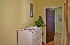 ein Zimmer mit einem weißen Schrank mit einer Pflanze darauf in der Unterkunft Apartment Palace in Rab