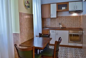 a small kitchen with a wooden table and chairs at Apartment Palace in Rab