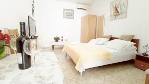 1 dormitorio con 1 cama y 1 botella de vino en AVA Studio apartment and Room, en Dubrovnik