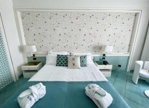 a bedroom with a bed with two pairs of shoes on it at Grand Hotel Terme in Margherita di Savoia